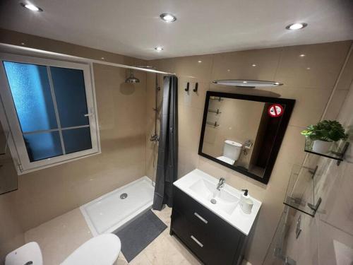 een badkamer met een toilet, een wastafel en een douche bij Apartamento San Eloy con plaza de garaje in Playa Honda