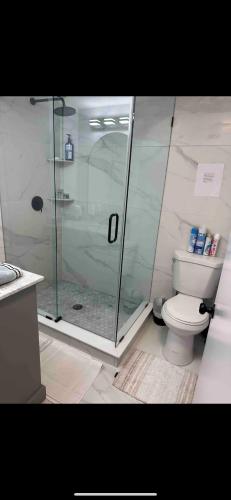 a bathroom with a glass shower and a toilet at Modern Beach Apartment in Long Branch