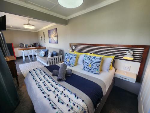 a bedroom with a large bed with blue and yellow pillows at Atlantis Haven in Sunrise-on-Sea