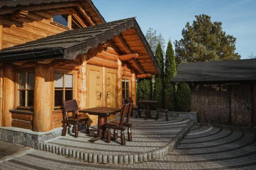 a wooden cabin with a table and chairs on a deck at Kompleks Tawerna Vito - Apartamenty Vito in Czorsztyn