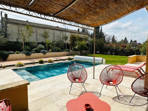 a patio with two chairs and a swimming pool at Le petit Mazet du Domaine avec sa piscine in Saint-Rémy-de-Provence