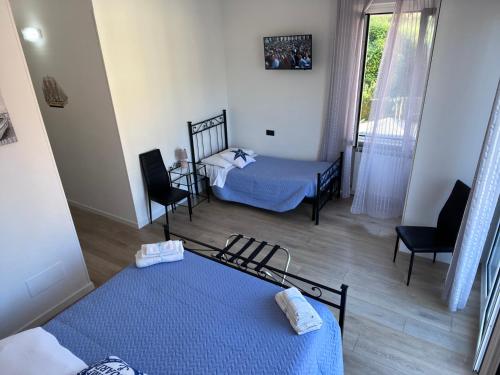 a room with two beds and two chairs and a window at Affittacamere Il Veliero in Levanto