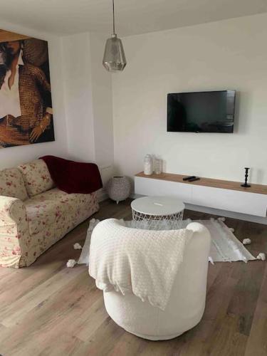 a living room with a couch and a chair at Le Rooftop d’Isa in Colombelles