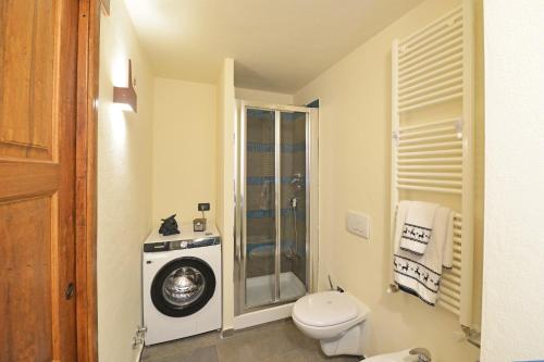 a bathroom with a toilet and a washing machine at L'Ame du Mont blanc vda.cir 0061 in Pré-Saint-Didier