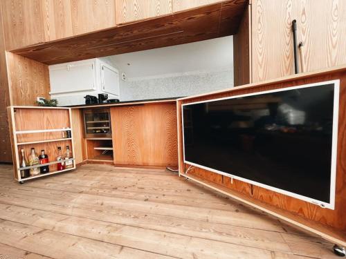 a large television in a kitchen with a wooden floor at Cabanon Le Perchoir des Goudes in Marseille