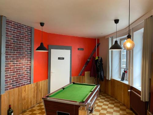 a room with a pool table and red walls at Auberge la grange in Égliseneuve-dʼEntraigues