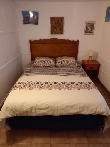 sypialnia z dużym łóżkiem z drewnianym zagłówkiem w obiekcie appartement climatisé 35 m2 pour 1 couple - piscine partagée - w mieście Porto-Vecchio