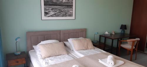 1 dormitorio con cama con sábanas blancas y escritorio en 2pokojowy apartament przy Starówce w Kołobrzegu, en Kołobrzeg