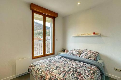 a bedroom with a bed and a window at Duplex T3 Hypercentre 65m² in Voiron