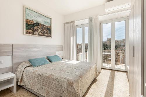 a bedroom with a bed and a large window at Hotel Minerva in Siena