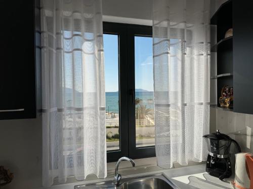 a kitchen with a window with a view of the ocean at SoleMar Suites in Vlorë