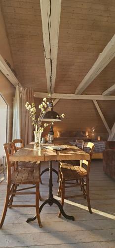 a wooden table with chairs and a vase of flowers at Blue Wall BnB in Gebenstorf