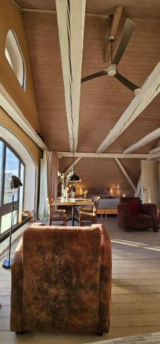 a living room with a couch and a ceiling fan at Blue Wall BnB in Gebenstorf