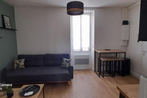un salon avec un canapé bleu et une table dans l'établissement Bel appartement rez-de-chaussée cour proche centre, à Bourges