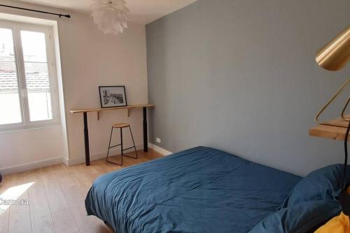une chambre avec un lit, une table et une fenêtre dans l'établissement Bel appartement rez-de-chaussée cour proche centre, à Bourges