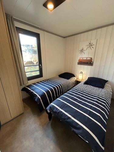 2 camas en una habitación con ventana en Kaz’a Ti Moun, en Jullouville-les-Pins