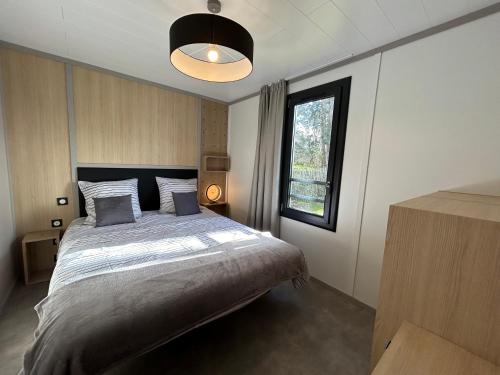 Un dormitorio con una cama grande y una ventana en Kaz’a Ti Moun, en Jullouville-les-Pins