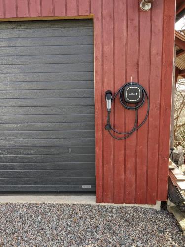 a garage door with a phone attached to it at Trevlig stuga på landet, centralt 8km från Centrum in Eskilstuna