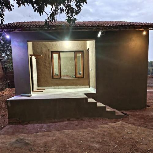 a small house with a window and stairs at Jungle joy Homestay Basata in Chhatarpur