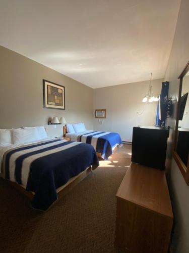 a hotel room with two beds and a television at Lake Ontario Motel & Inn in Newfane