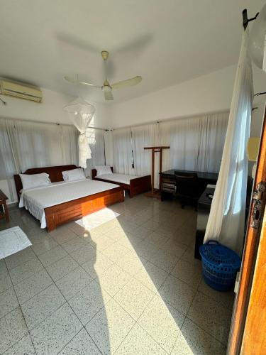 a large bedroom with a bed and a couch at Ramaya Auberge Espagnole in Grand-Popo
