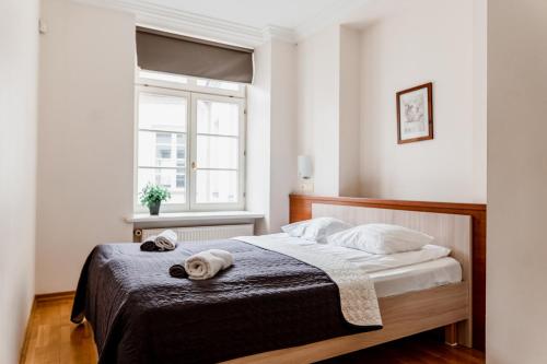 a bedroom with a bed with towels on it at Town Hall Square Apartment with Sauna in Tallinn