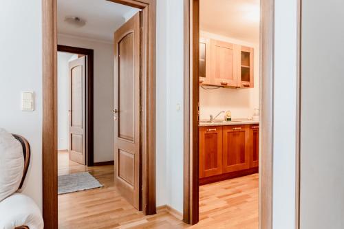 a kitchen with a door leading into a room at Town Hall Square Apartment with Sauna in Tallinn