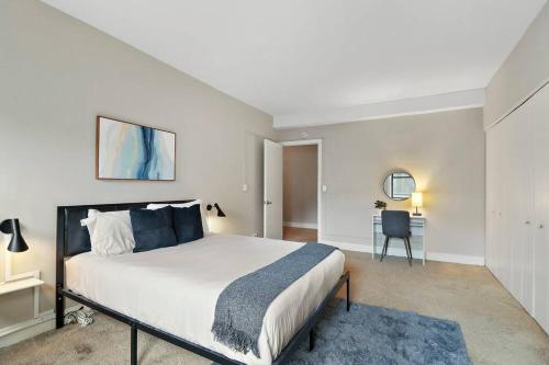a bedroom with a large bed and a desk at Sunny 2-Bedroom Sanctuary in Hyde Park - Windermere 211 in Chicago