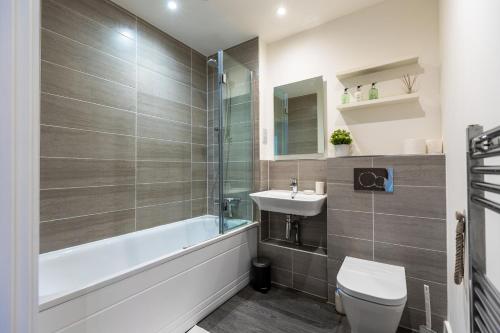 a bathroom with a sink and a toilet and a bath tub at Cosy 1 bed near peaceful canal By Valore Property Services in Milton Keynes