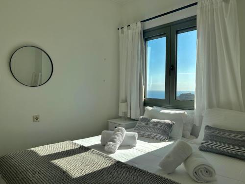 a white bedroom with a large window with towels on a bed at Horizon Villa Mani - Seaview Family Friendly House in Stoupa