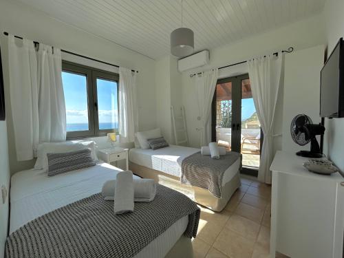 2 camas en una habitación con vistas al océano en Horizon Villa Mani - Seaview Family Friendly House, en Stoupa