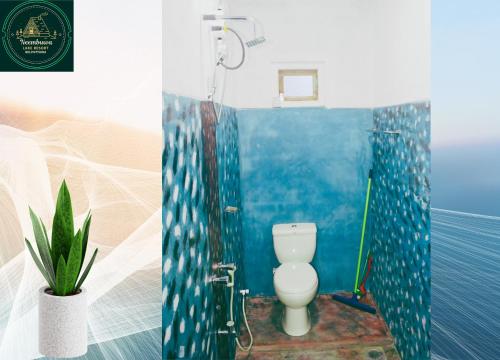 a bathroom with a toilet and a blue wall at Neembuva Resort in Pahala Maragahawewa