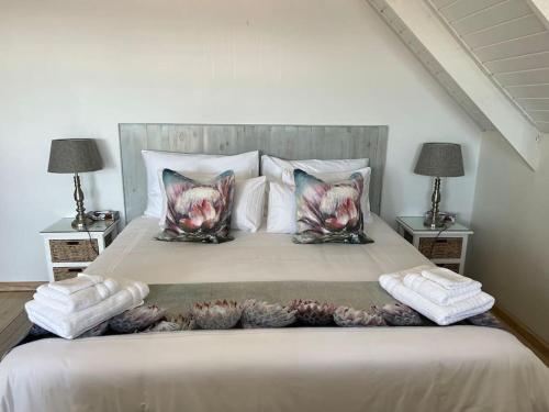 a bedroom with a large bed with two night stands at Tranquility Betty's Bay in Sunny Seas