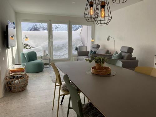 ein Wohnzimmer mit einem Tisch, Stühlen und einem Sofa in der Unterkunft Lorez 5E by Arosa Holiday in Arosa