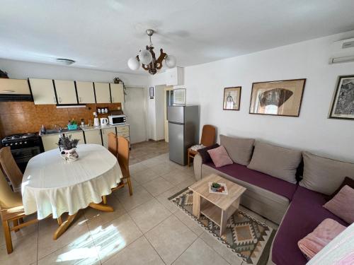 Il dispose d'une cuisine et d'un salon avec une table et un canapé. dans l'établissement Apartment Marijeta Kaštela, à Kaštela