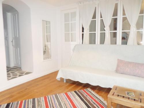 a white living room with a couch and a table at In the heart of Hydra in Hydra