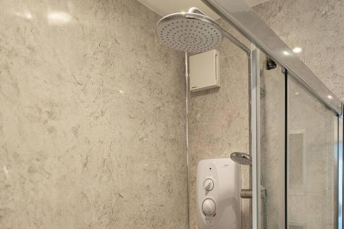 a shower with a glass door in a bathroom at The Old Fire Station at Colerne in Chippenham