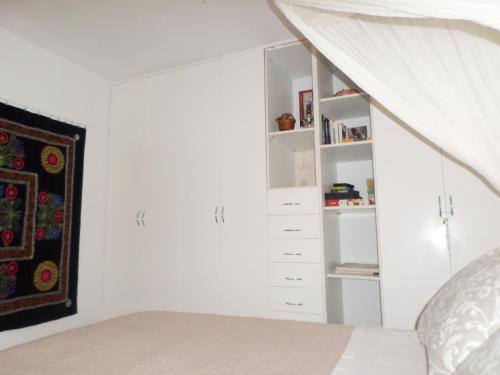 a white bedroom with a bed and a closet at In the heart of Hydra in Hydra