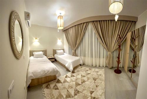a hotel room with two beds and a mirror at Luxury Villa Bali Al Gouna Hurgh in Hurghada