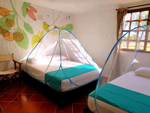 1 dormitorio con 1 cama con dosel en HERMOSA CABAÑA VILLA JULIA MESA DE LOS SANTOS, en Piedecuesta