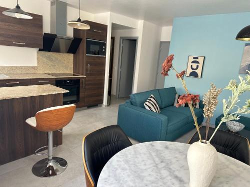 un salon avec un canapé bleu et une table dans l'établissement CARLIT, à Port-Vendres