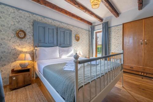 een slaapkamer met een bed met een blauw hoofdeinde bij Villa Paradis 13 in Butkovići