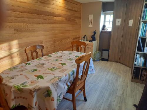 une salle à manger avec une table et deux chaises dans l'établissement La fermette - chambres d'hôtes dans environnement calme et arboré, à Saint-Jean-des-Baisants