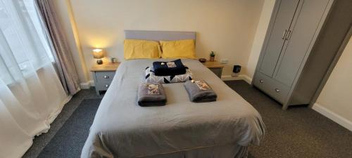 a bedroom with a large bed with two bags on it at Room 3 Penrhyn drive in Llandrillo-yn-Rhôs