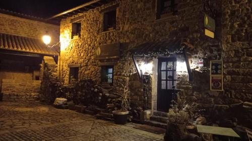 a stone building with a blue door at night at Posada Reserva Verde in Bárcena Mayor
