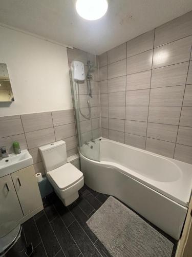 a bathroom with a tub and a toilet and a sink at One bedroom flat and spare bed in Bristol