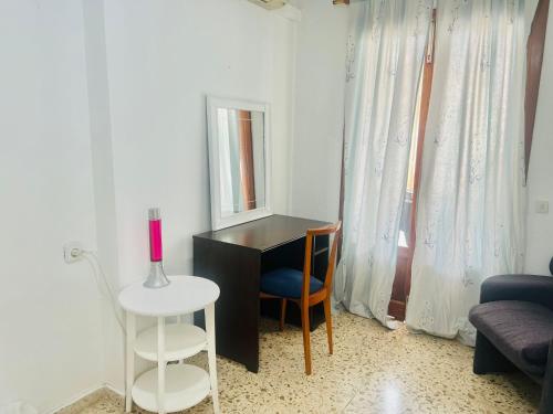 Zimmer mit einem Schreibtisch, einem Stuhl und einem Spiegel in der Unterkunft Habitacion RUSTICA en Palma para una sola persona en casa familiar in Palma de Mallorca