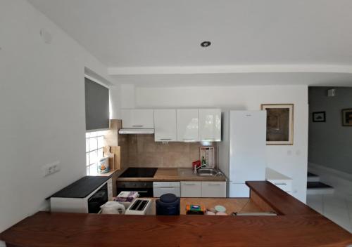 a kitchen with white cabinets and a wooden counter top at Apartments Finera in Pomer