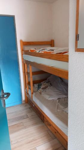 Joli studio avec balcon donnant sur la montagne في سانت-ماري-دي-كامبان: سريرين بطابقين في غرفة صغيرة مع مدخل