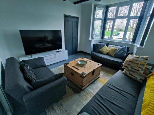 a living room with two couches and a flat screen tv at Modern 3 bedroom house in Birmingham